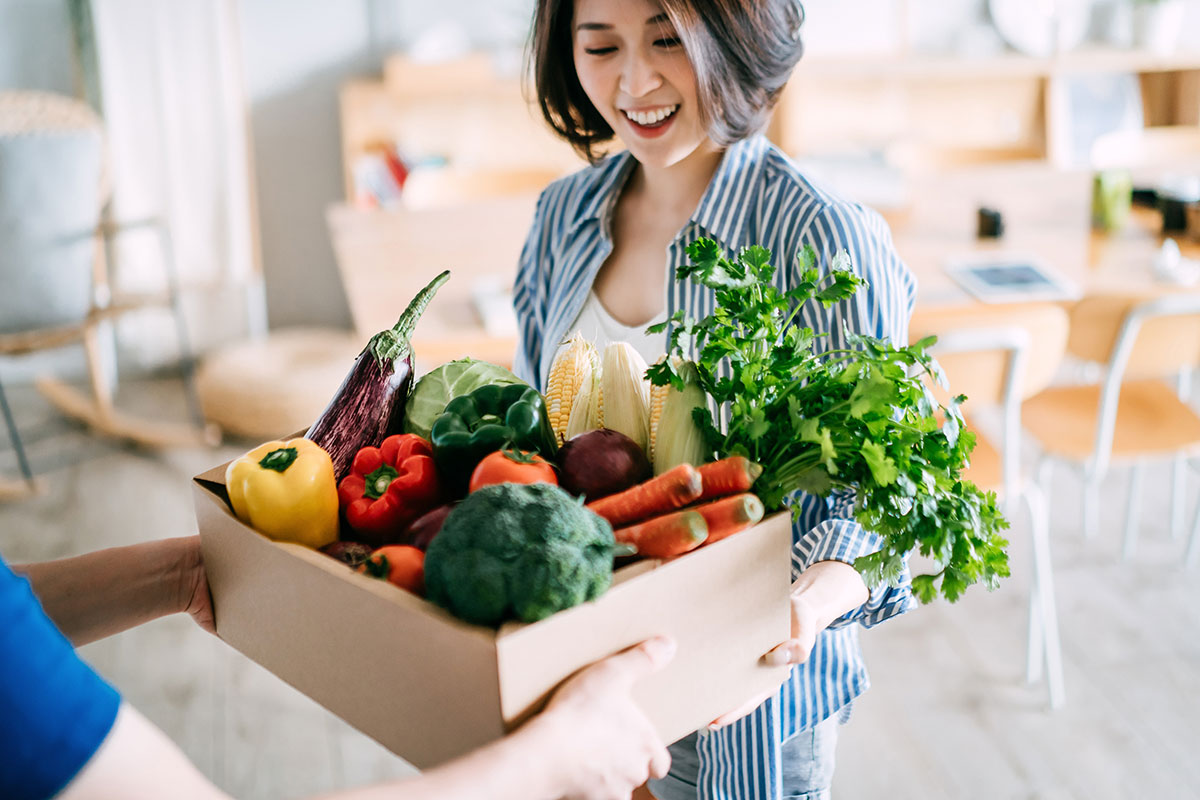 woman with box of vegetables