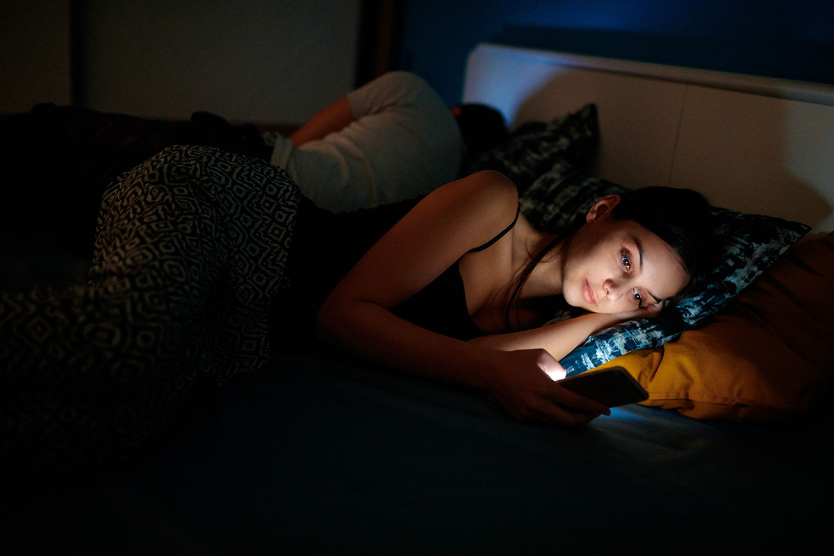 young woman on phone in bed