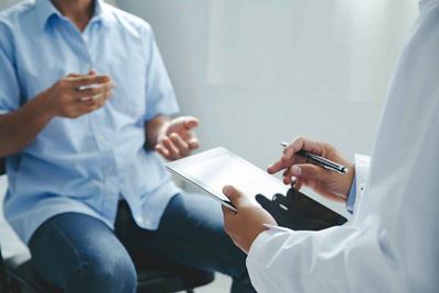 Doctor talks to patient about head and neck cancer