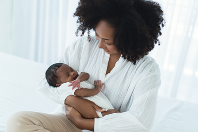 postpartum woman holds newborn baby