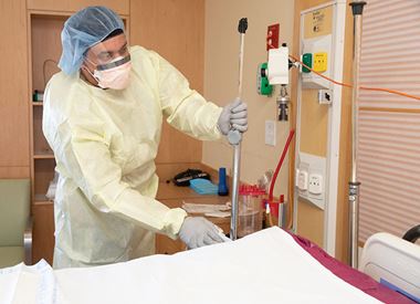 Health worker sanitizing a hospital bed