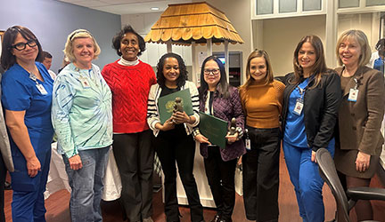 Normadene Devane, RN, and Eloisa Zano-Samuel, RN, (center, holding certificates) recently earned the DAISY Award for their compassionate care of a long-term patient.