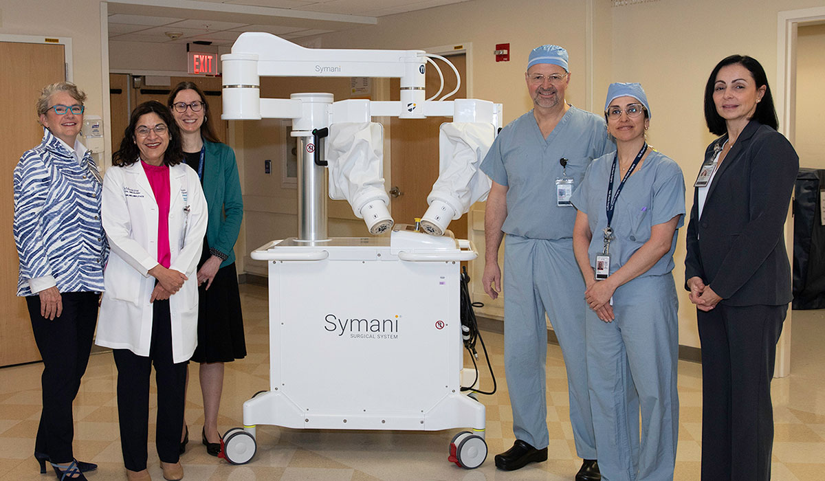 With the Symani Surgical System robot are (l-r): Katherine Heilpern, MD, president, YNHH; Nita Ahuja, MD, chief of Surgery, YNHH, and chair of Surgery, YSM; Marie-Helene Gratton, vice president, Digestive Health, Urology, Dermatology and Plastic Surgery, YNHH; Bohdan Pomahac, MD, chief, Plastic and Reconstructive Surgery, YNHH, and professor of Surgery, YSM; Siba Haykal, MD, section chief of Reconstructive Oncology, YNHH, and associate professor, YSM; and Alfonsina Fraschilla, administrator, Division of Surgery, YSM.