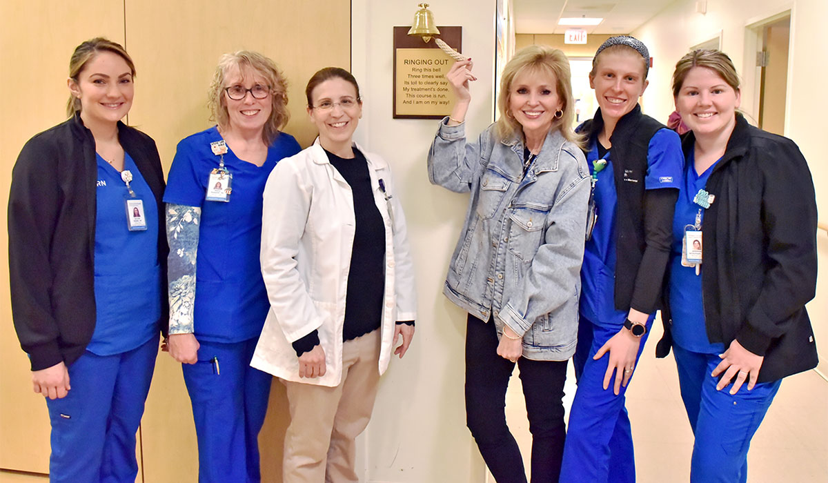 Carol Blackburn of Ledyard (holding bell) with her care team at the L+M Wound & Hyperbaric Center in Waterford