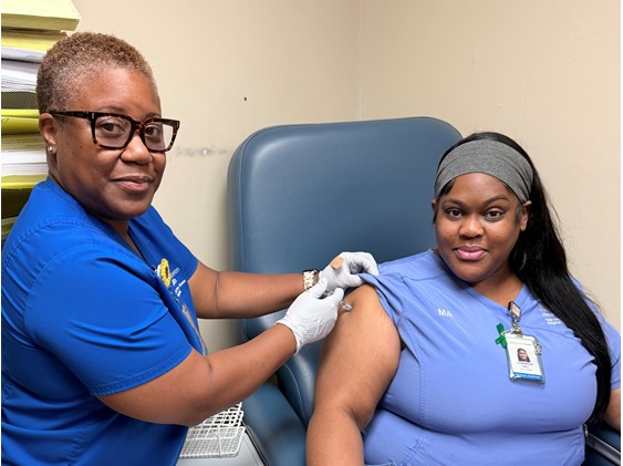 Joy Burke-Hopkins, RN (left), administered a flu vaccine to Charmaine Hall