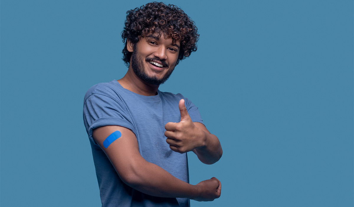 Man giving a thumbs up with a bandaid on his arm