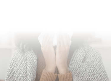 Blurred hands holding tissue to face