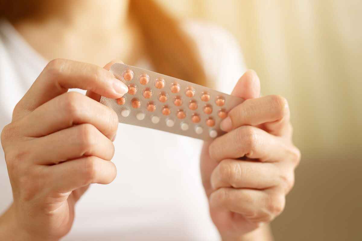 Female patient holding birth control pills
